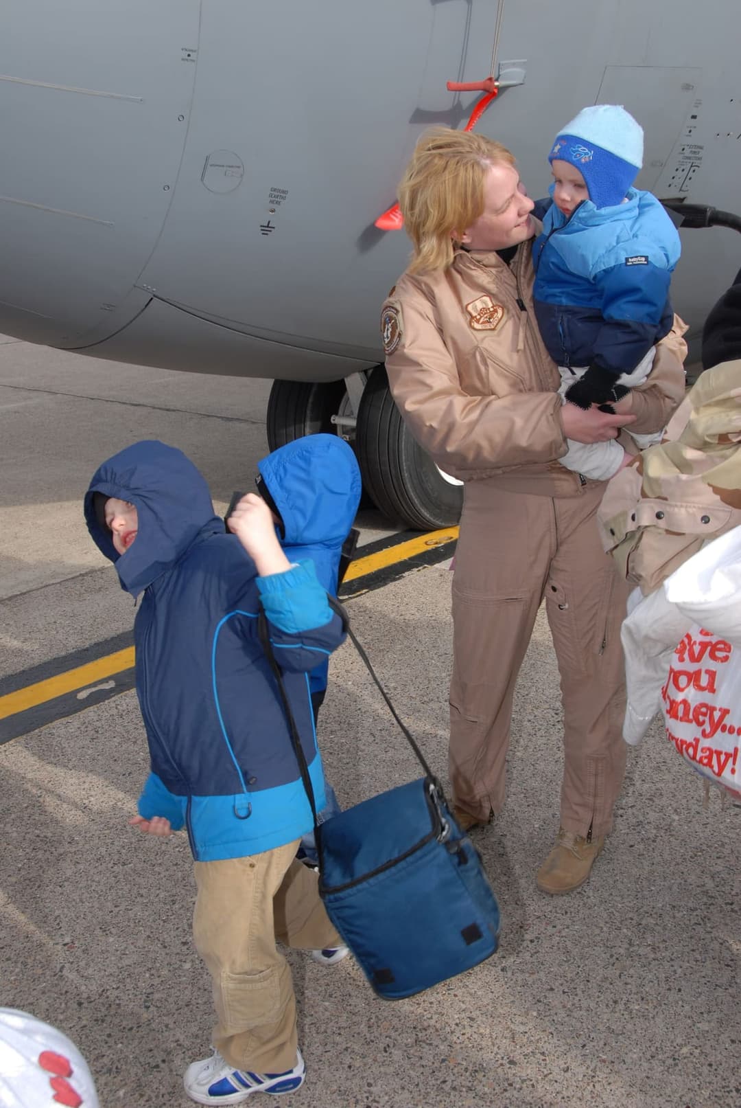 A U.S. service member reunites with her children at an airport terminal after a long trip