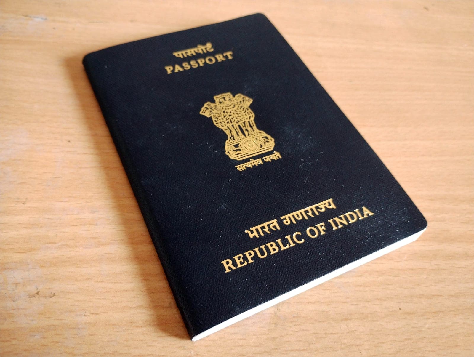 An Indian passport on a wooden table