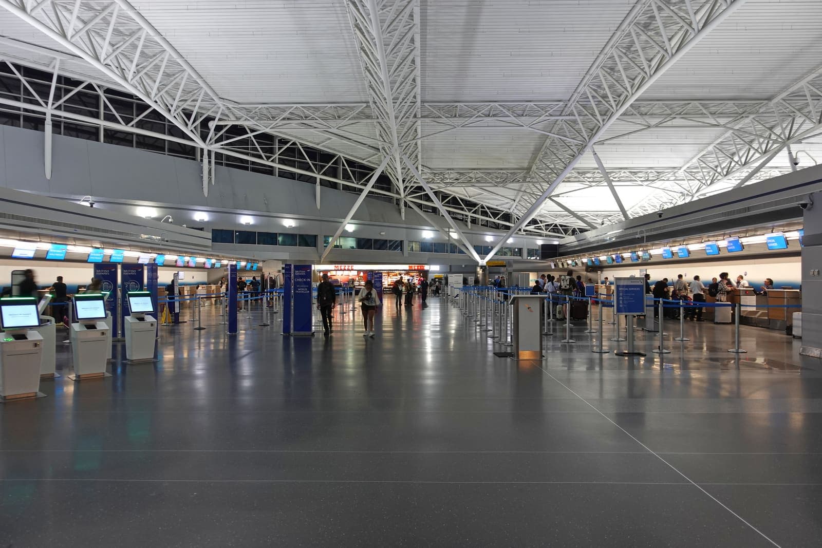 Travelers checking in at the international departure hall of JFK Airport's Terminal 8 in New York